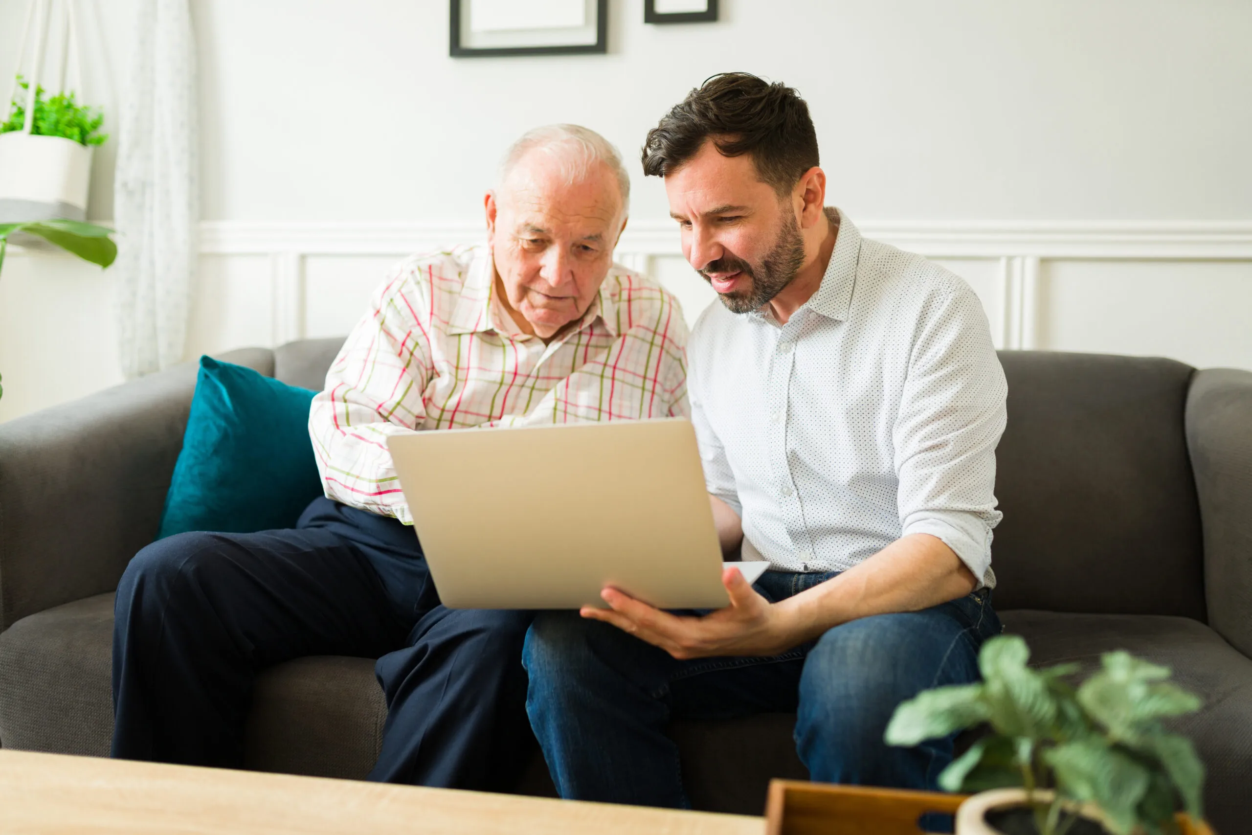 Older man and younger man looking at laptop together